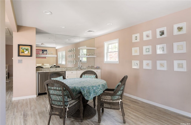 dining space with visible vents, baseboards, and light wood finished floors