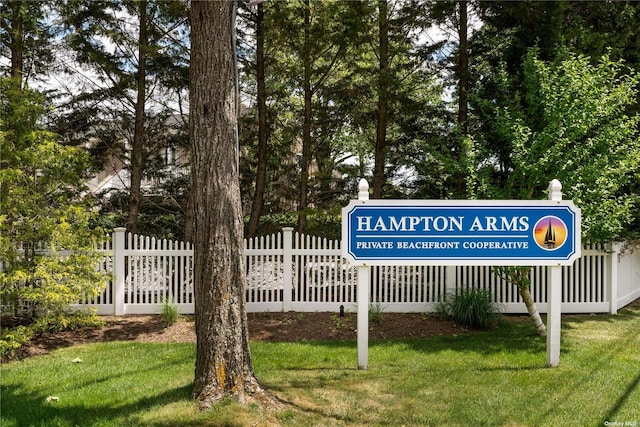 view of home's community with a lawn and fence