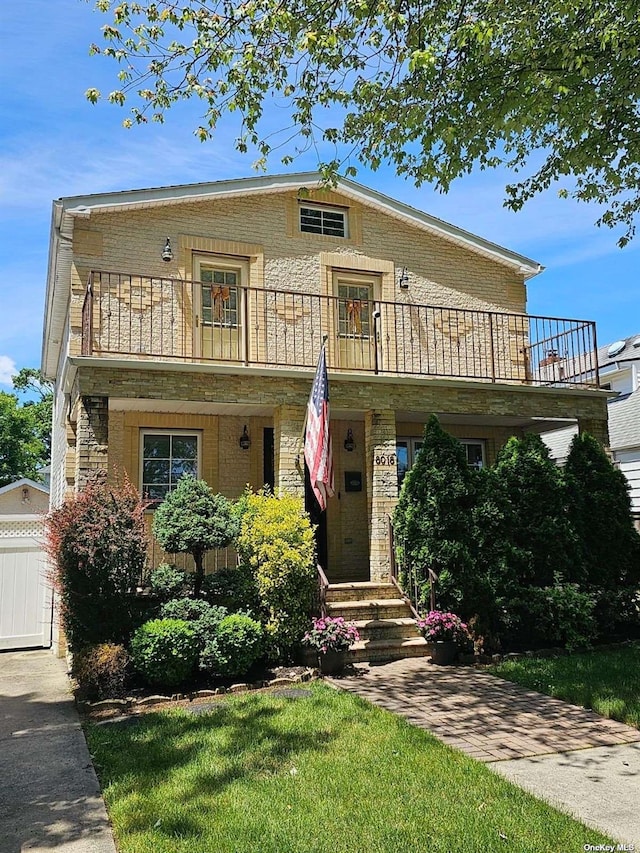 view of front of house with a balcony and brick siding