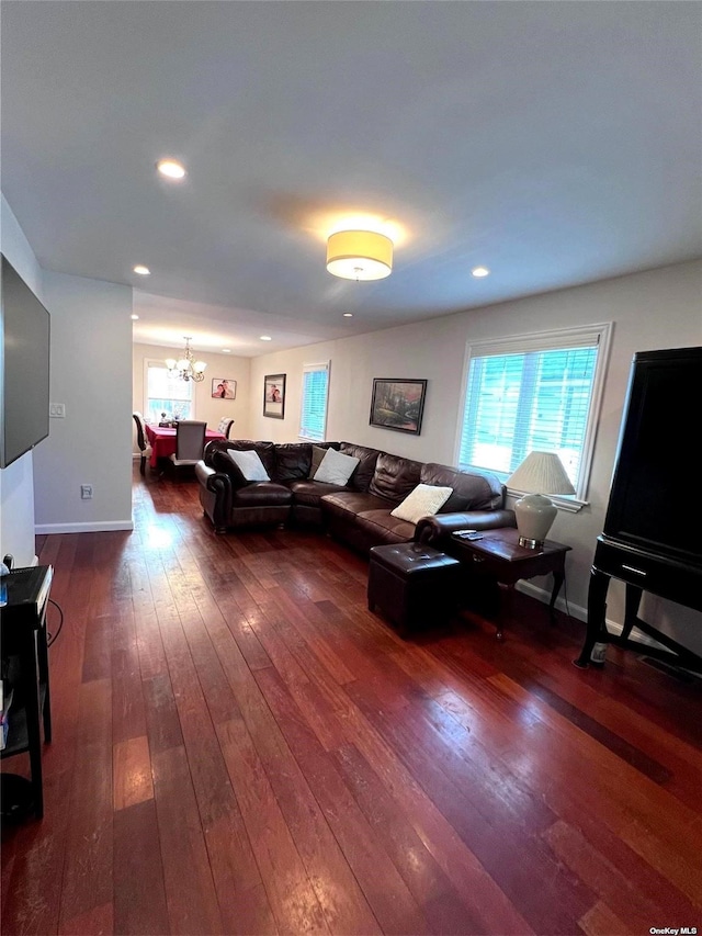 living area with recessed lighting, baseboards, an inviting chandelier, and wood-type flooring