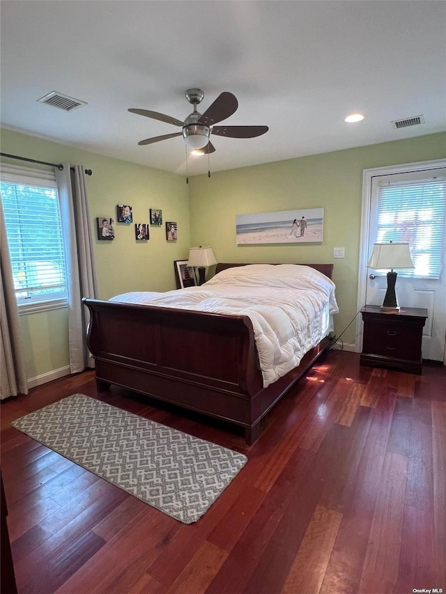 bedroom featuring visible vents, baseboards, and dark wood finished floors