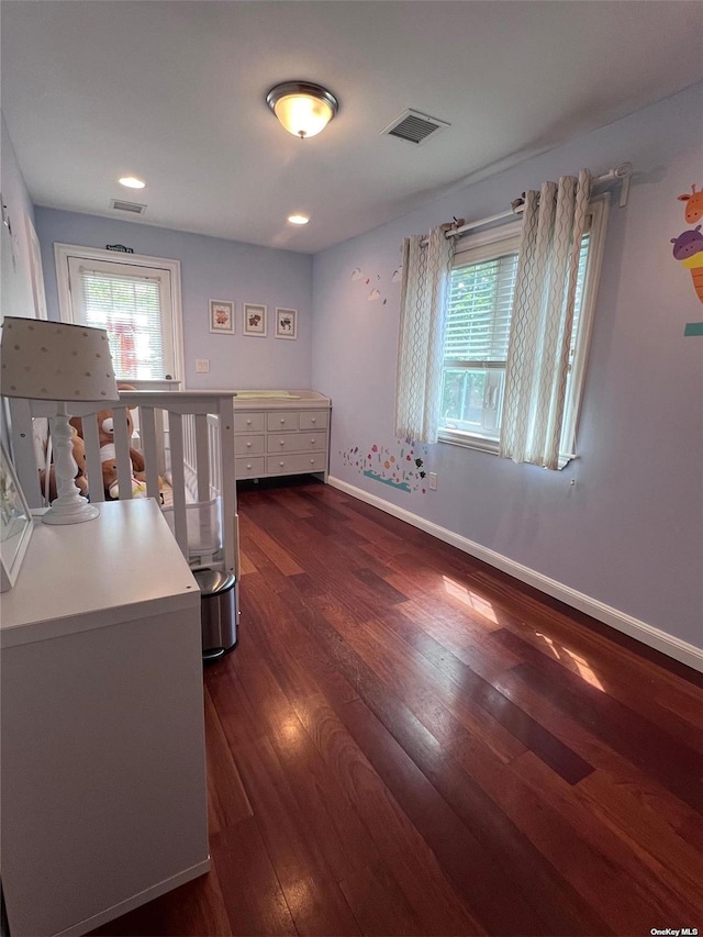 bedroom featuring visible vents, multiple windows, baseboards, and dark wood-style flooring