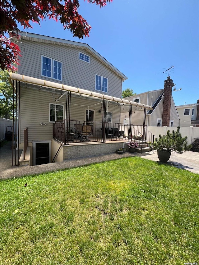 rear view of house with a patio area, fence, and a lawn