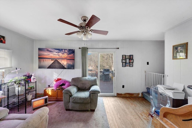 living area with a ceiling fan and wood finished floors