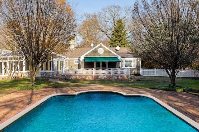 view of pool with a fenced in pool, a lawn, a wooden deck, and fence