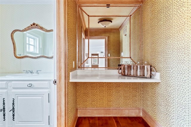 bathroom with wallpapered walls, vanity, and wood finished floors