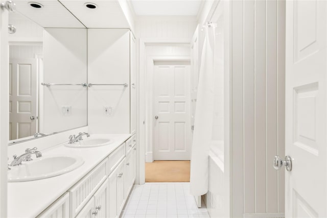 bathroom featuring a sink, shower / tub combo with curtain, double vanity, and tile patterned floors