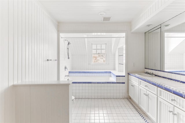 full bathroom featuring tile patterned flooring, tiled shower / bath, vanity, and visible vents