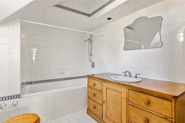 bathroom featuring tile patterned floors, tile walls, vanity, and tiled shower / bath combo