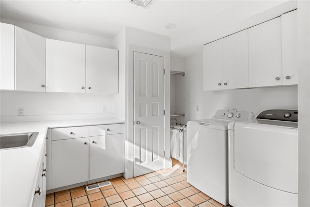 washroom with visible vents, light tile patterned floors, separate washer and dryer, cabinet space, and a sink