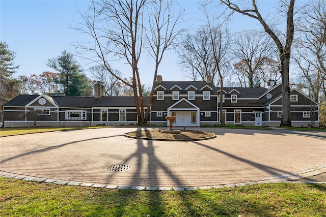 view of front of home featuring a chimney and decorative driveway