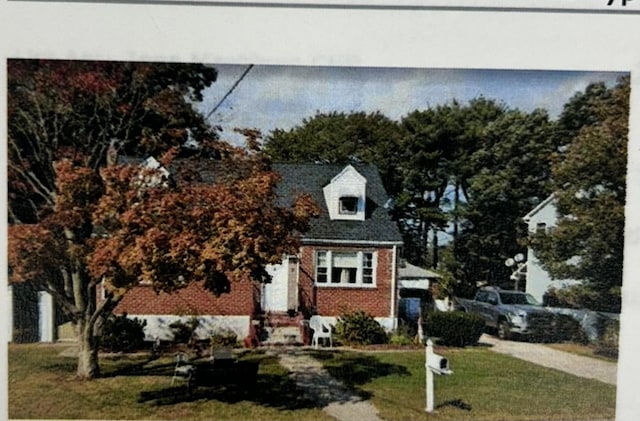 view of front of house featuring brick siding and a front lawn