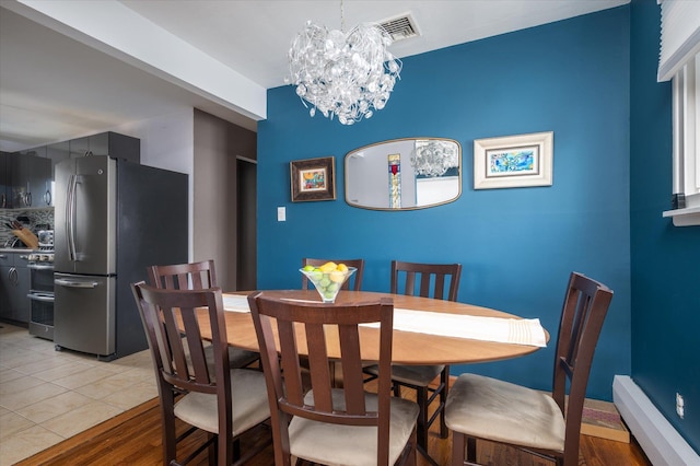 dining room featuring light tile patterned floors, visible vents, and a chandelier