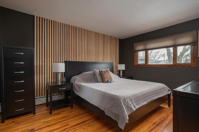 bedroom featuring light wood-style flooring and a baseboard radiator