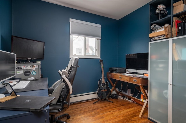 home office featuring a baseboard heating unit and wood finished floors