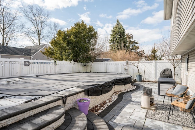 view of patio / terrace with a covered pool and a fenced backyard