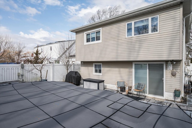 rear view of property featuring a patio and fence