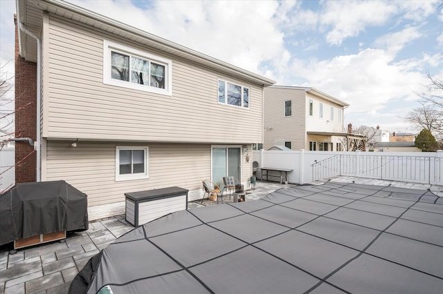 rear view of property featuring a patio and fence