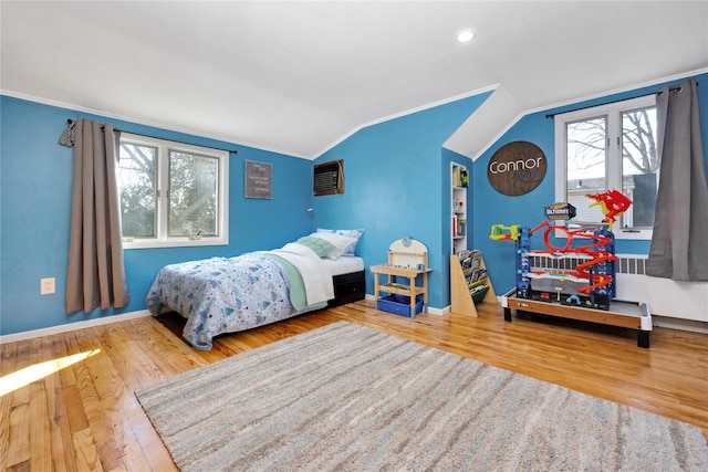 bedroom with ornamental molding, hardwood / wood-style flooring, baseboards, and vaulted ceiling