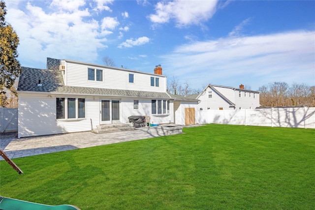 rear view of property with entry steps, a yard, and a fenced backyard