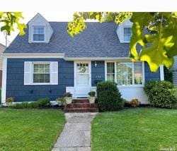 new england style home featuring a front lawn