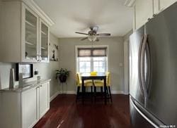 kitchen with dark wood-style floors, freestanding refrigerator, glass insert cabinets, baseboards, and ceiling fan