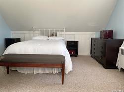 bedroom featuring light colored carpet and vaulted ceiling