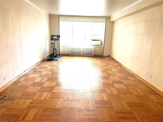 empty room featuring cooling unit, baseboards, and crown molding