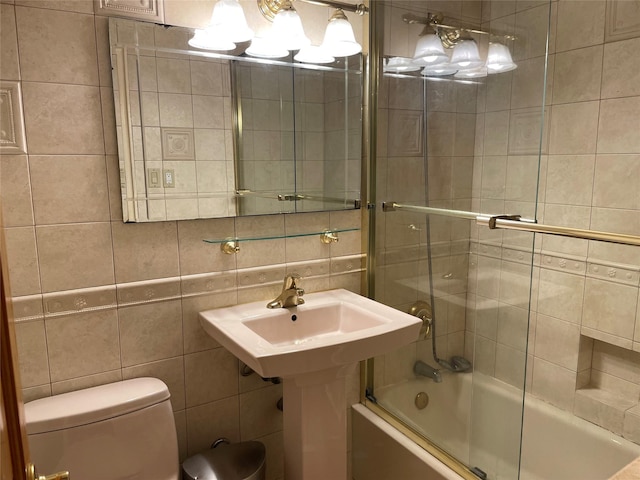 full bath featuring enclosed tub / shower combo, toilet, and tile walls