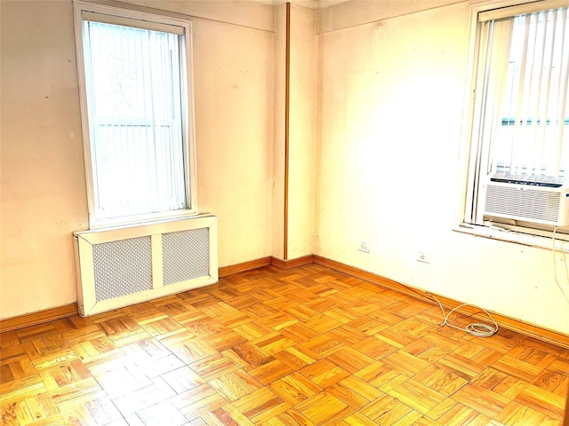 spare room with radiator heating unit, cooling unit, and baseboards