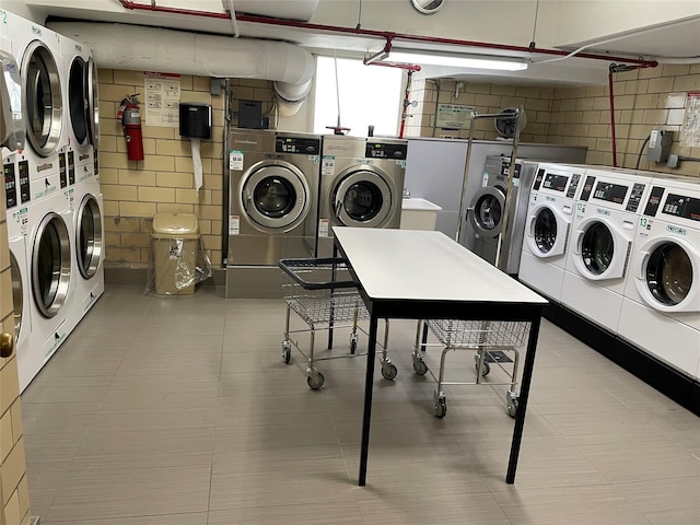 shared laundry area featuring tile patterned flooring, stacked washer and clothes dryer, and washer and clothes dryer