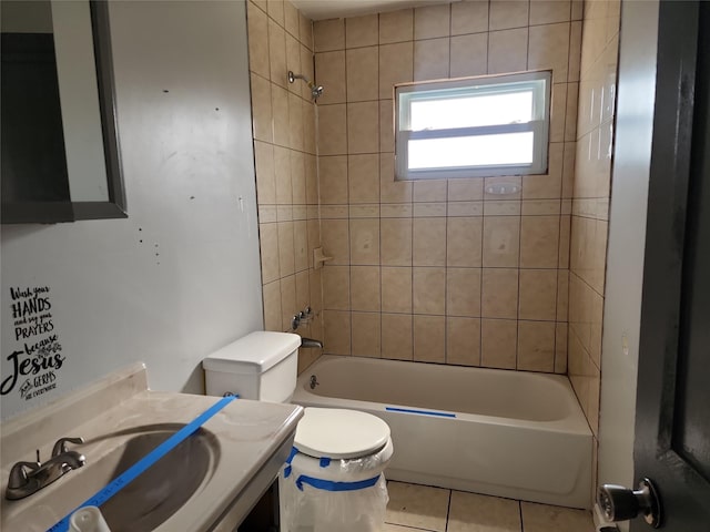 bathroom featuring tile patterned flooring, bathing tub / shower combination, toilet, and a sink