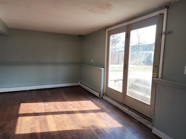 unfurnished room featuring a wainscoted wall and wood finished floors