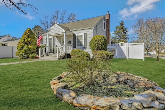 view of front facade featuring a shingled roof, fence, a front yard, a chimney, and a gate