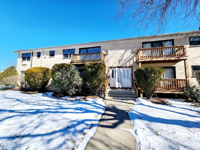 multi unit property featuring a balcony and brick siding