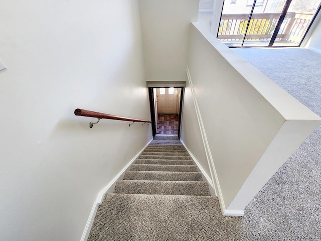 stairway with a towering ceiling, baseboards, and carpet floors