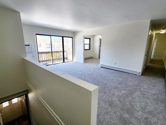 carpeted empty room with a wall mounted air conditioner and a baseboard radiator