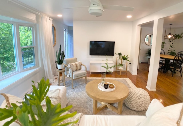 living area with wood finished floors, baseboards, and a ceiling fan