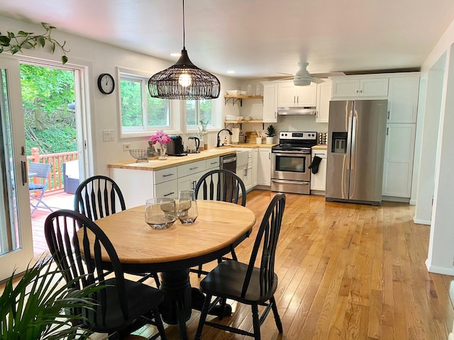 dining area with light wood finished floors and a ceiling fan