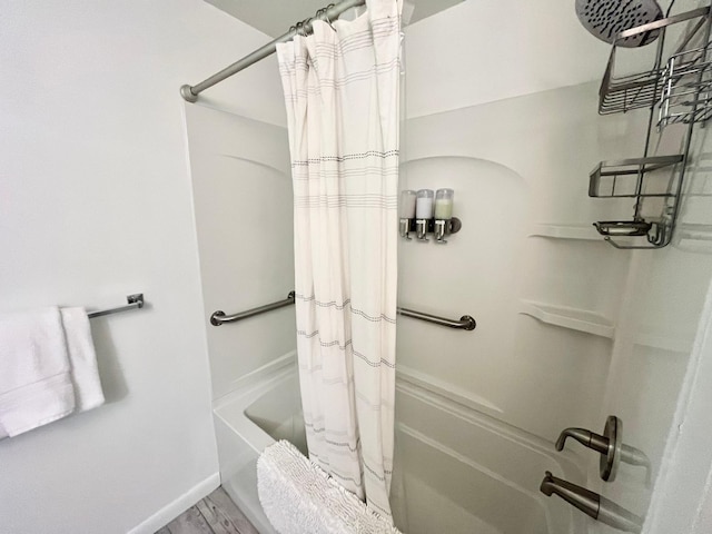bathroom with shower / tub combo with curtain, wood finished floors, and baseboards