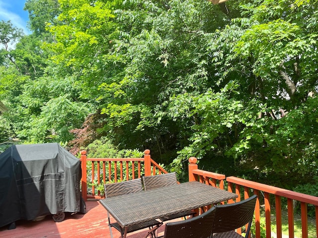 wooden deck featuring grilling area and outdoor dining area