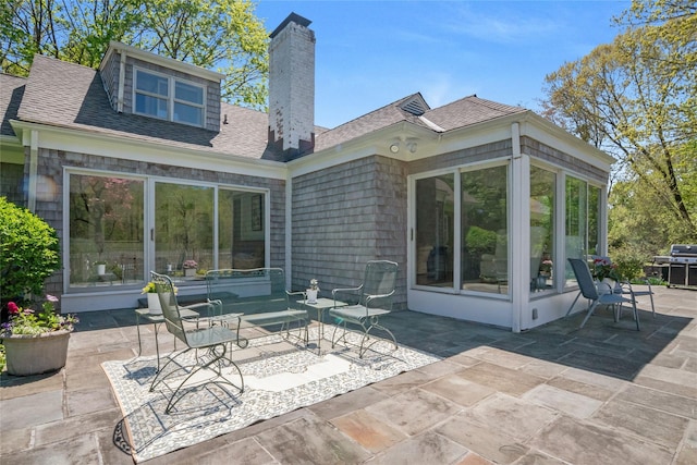 33 N Way, Chappaqua, NY 10514 - back of house with a shingled roof, a chimney, a sunroom, and a patio area