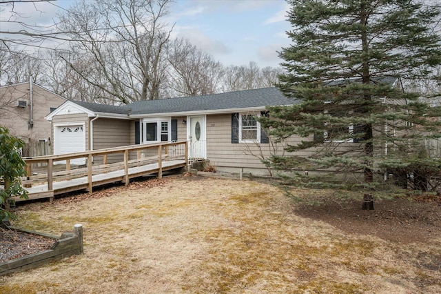 view of front of home with a deck, an attached garage, and roof with shingles