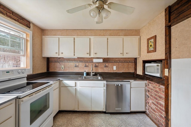 kitchen featuring white appliances, dark countertops, tasteful backsplash, and a sink