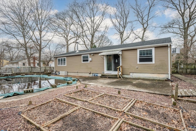 back of property featuring a fenced in pool, fence, entry steps, a garden, and a patio