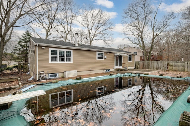 rear view of property with entry steps and fence