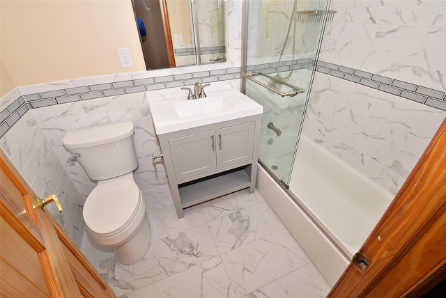 bathroom featuring vanity, a wainscoted wall, shower / tub combination, toilet, and marble finish floor