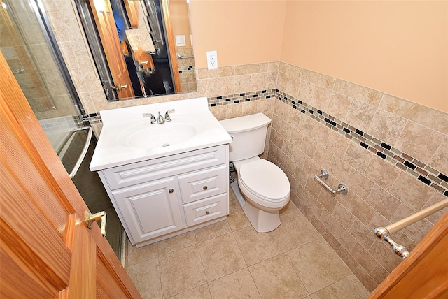 bathroom with tile walls, tile patterned floors, toilet, and vanity