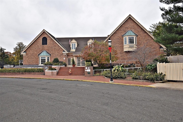 view of front of property featuring brick siding and fence