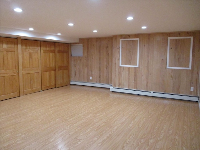 unfurnished room featuring recessed lighting, a baseboard heating unit, and light wood-style floors